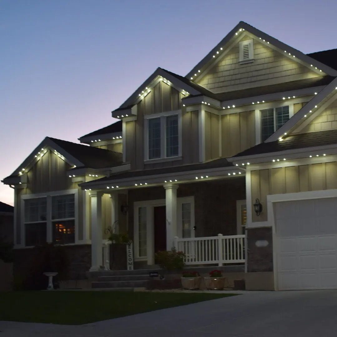 Craftsman home glowing warm white at dusk